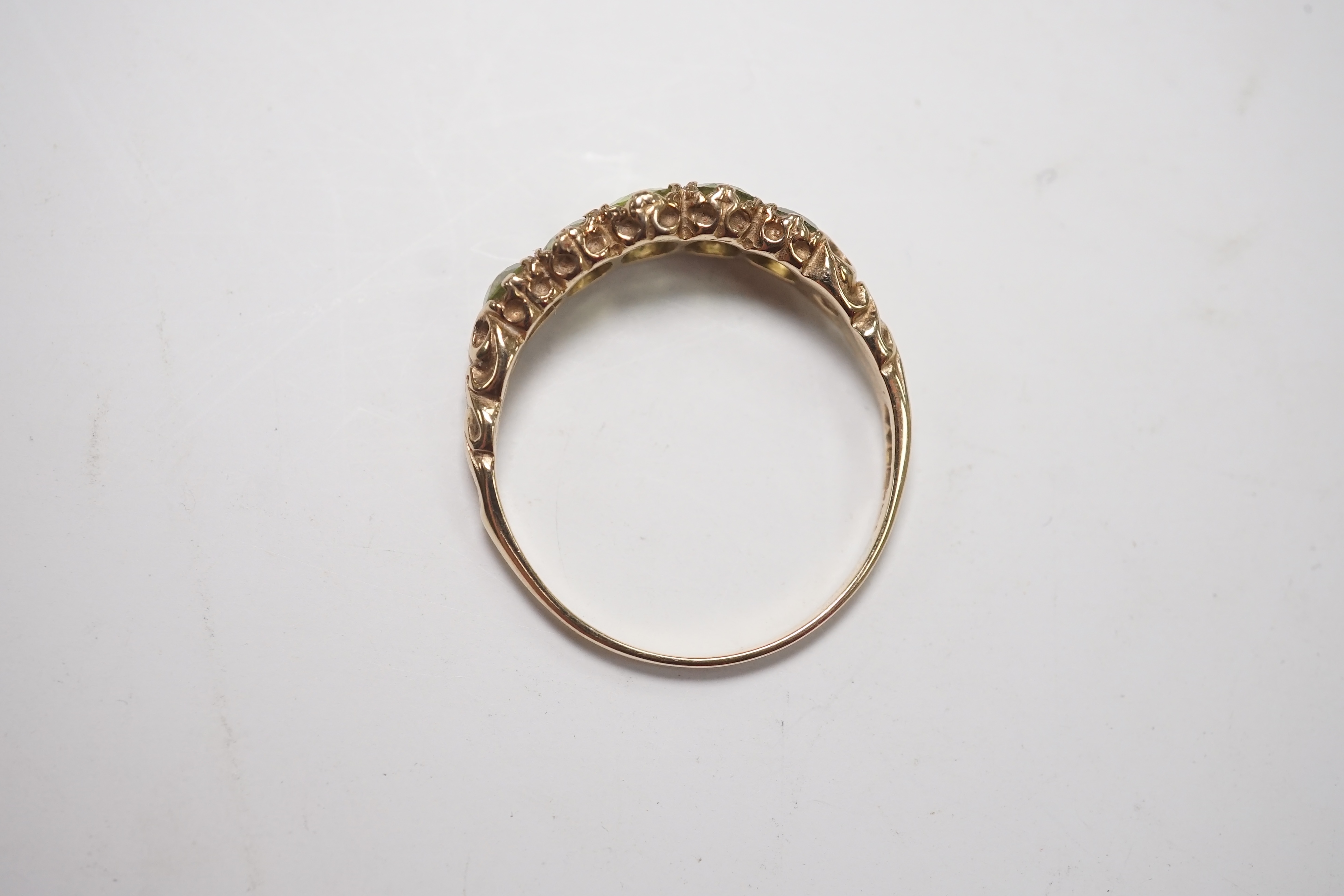 A 9ct and graduated five stone peridot set half hoop ring, size V, a 9ct gold and cameo shell ring and a gem set stickpin. Condition - poor to fair